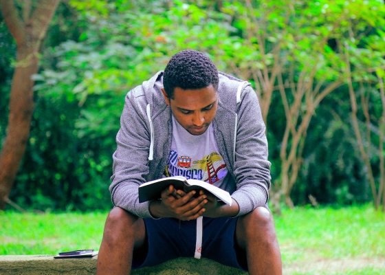 Man reading Scripture in park