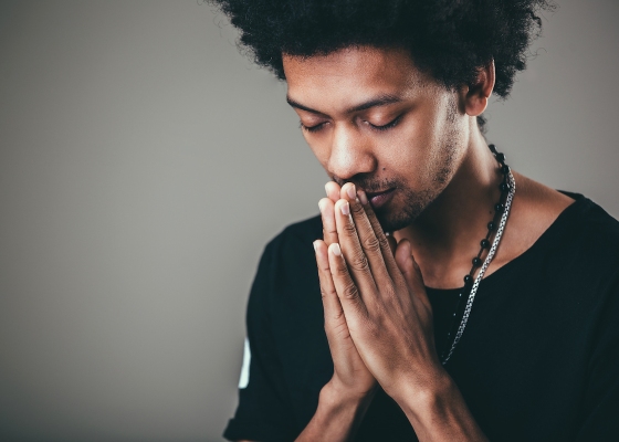 Man in black t-shirt praying