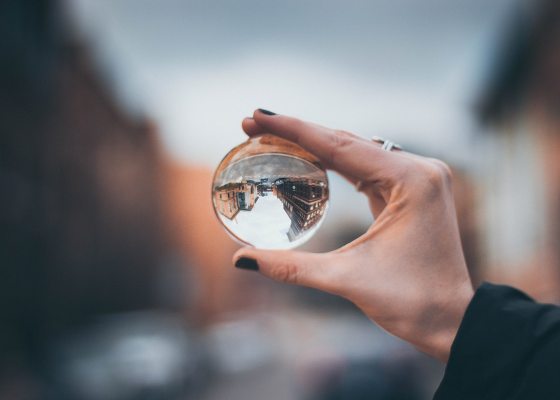 Person holding reflective glass orb